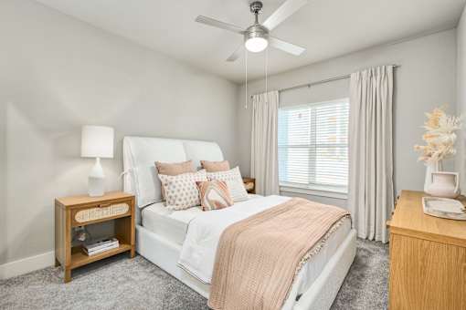 A bedroom with a bed, nightstand, and a ceiling fan at The Ashton at East Park Apartments, Kennesaw, GA, 30144