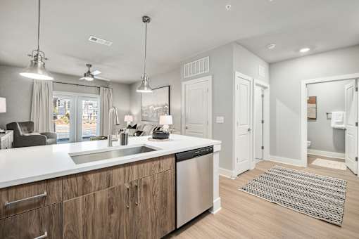 A modern kitchen with wooden cabinets and stainless steel appliances at The Ashton at East Park Apartments, Kennesaw, GA