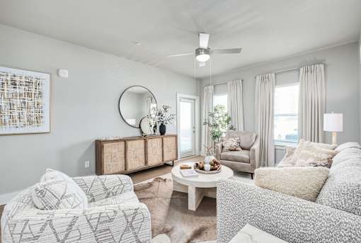 A living room with a white couch, a wooden cabinet, and a painting on the wall at The Ashton at East Park Apartments, Kennesaw, 30144
