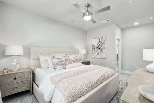 A bedroom with a large bed and a ceiling fan at The Ashton at East Park Apartments, Kennesaw