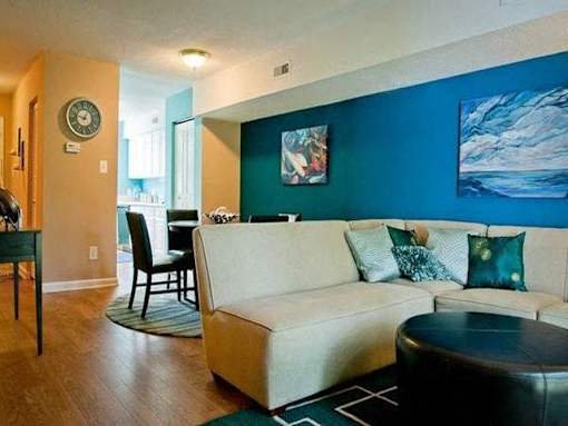 Living room with a blue accent wall at Emory Woods Apartments, Durham, North Carolina.