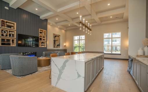 A modern living room with a fireplace and a large marble island at The Ashton at East Park Apartments, Kennesaw, GA
