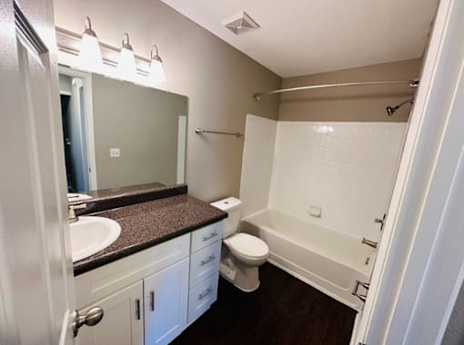 A bathroom with a toilet, sink, and bathtub.