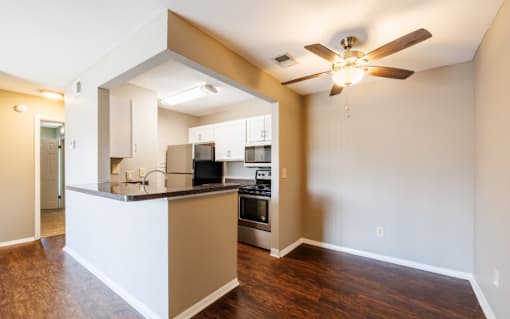 A kitchen with a white island and a ceiling fan.