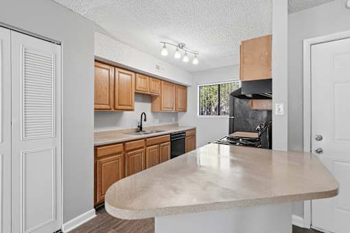 A kitchen with wooden cabinets and a beige island.