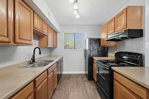 A kitchen with wooden cabinets and black appliances.