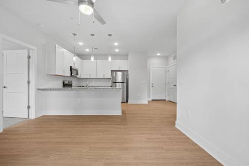 Open concept kitchen with white cabinets and granite countertop at The Palms Apartments, Charleston