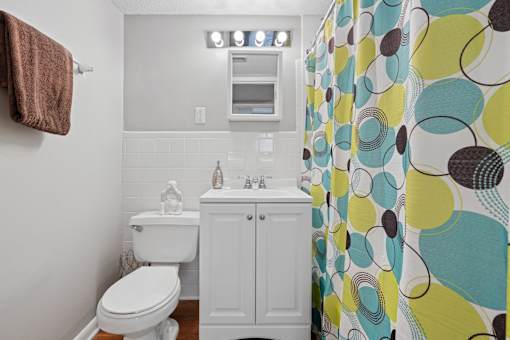 Bathroom with white vanity and colorful shower curtain at The Palms Apartments, Charleston, SC 29407