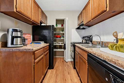 Galley kitchen with wood cabinets and granite countertops at The Palms Apartments, Charleston, 29407