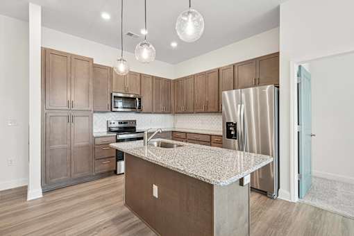 A kitchen with brown cabinets and a granite countertop.