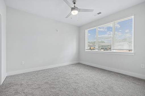 Empty bedroom with ceiling fan and window blinds at The Palms Apartments, Charleston, SC 29407