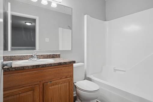 A bathroom with a toilet, sink, and bathtub.