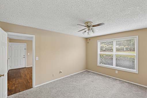A room with a ceiling fan and a window.