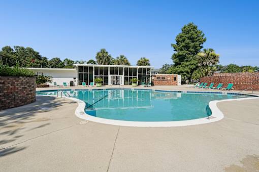 Outdoor swimming pool with midcentury modern clubhouse at The Palms Apartments, Charleston, South Carolina