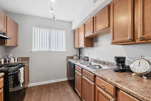 A kitchen with wooden cabinets and a granite countertop.