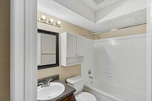 A bathroom with a white toilet, sink, and bathtub.