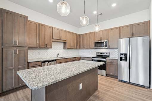 A kitchen with wooden cabinets and a granite countertop.