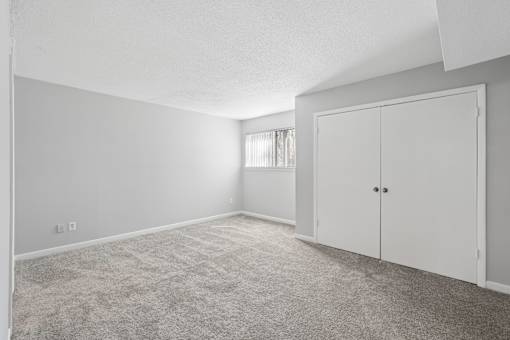 A room with a carpeted floor and a white door.
