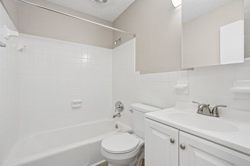 White bathroom with tub shower and vanity at The Palms Apartments, South Carolina, 29407