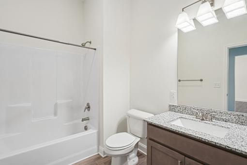 A white toilet sits next to a sink in a bathroom.