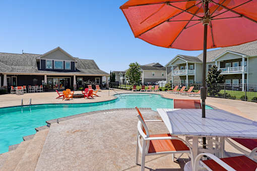 A large orange umbrella is in the foreground of a pool area. at The Lory of Greenway Village Apartments, Ky