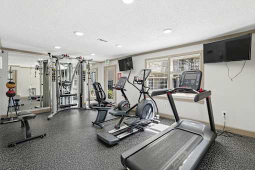 A spacious gym with treadmills, weights, and exercise equipment.