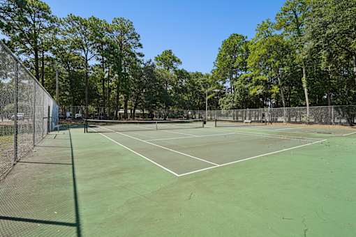 Tennis court with net and fenced perimeter at The Palms Apartments, South Carolina, 29407