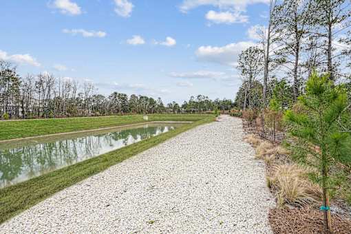 A gravel path runs alongside a body of water.