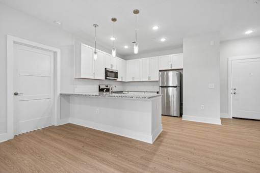 Contemporary kitchen with peninsula bar and white cabinets at The Palms Apartments, Charleston