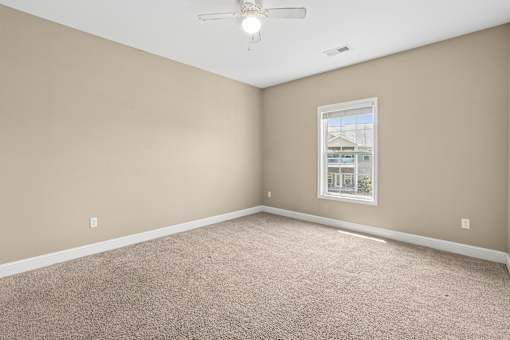 Spacious bedroom with window and neutral tones at The Lory of Greenway Village Apartments, Kentucky,