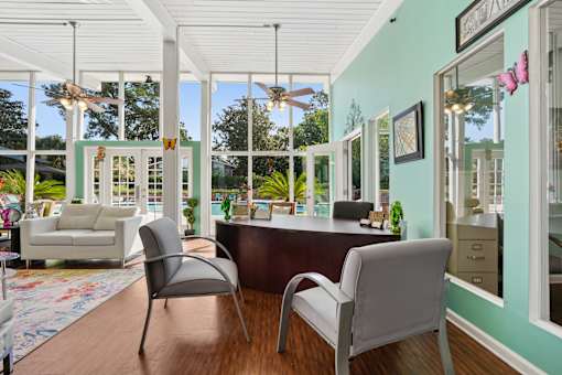 Sunroom office with large windows and ceiling fan at The Palms Apartments, Charleston, SC 29407