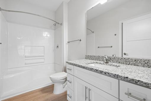 Bathroom with granite countertop and white cabinetry at The Palms Apartments, Charleston, SC