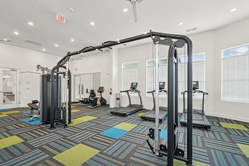 A gym with a variety of equipment including treadmills and weight machines.