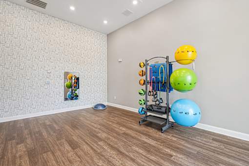A room with a wooden floor and a wall with a patterned wallpaper.