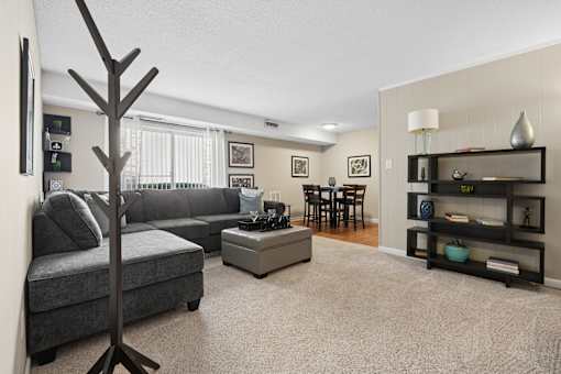 Living room with sectional sofa and dining area at The Palms Apartments, South Carolina