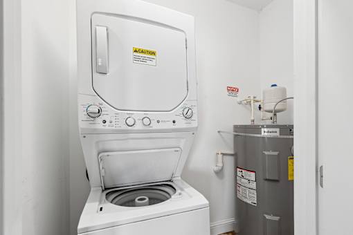 A washing machine with a caution sign on it. at The Lory of Greenway Village Apartments, Kentucky