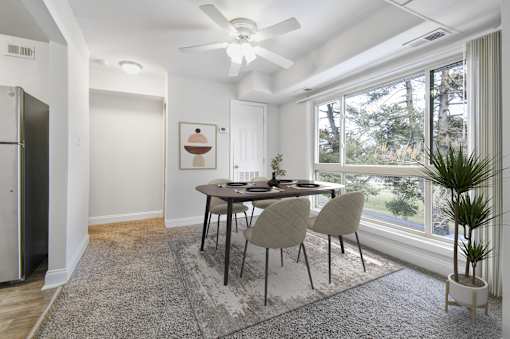 A dining room with a table and chairs.