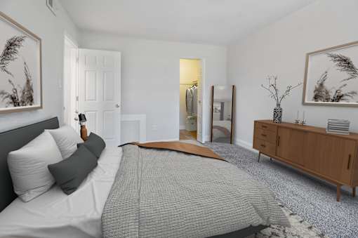 A bedroom with a large bed and a wooden dresser.