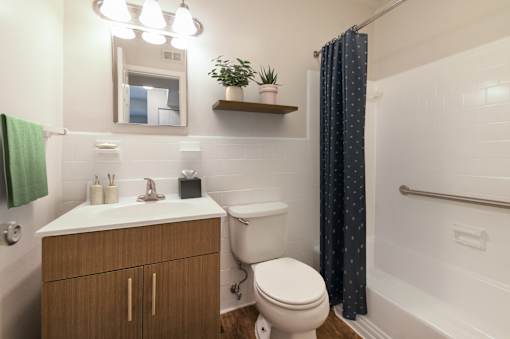A bathroom with a toilet, sink, and shower.