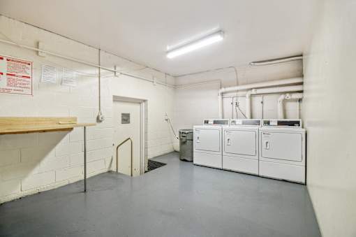 A clean, empty industrial room with white cabinets and a door at the back.