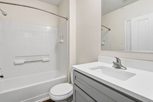 A white bathroom with a toilet, sink, and bathtub.