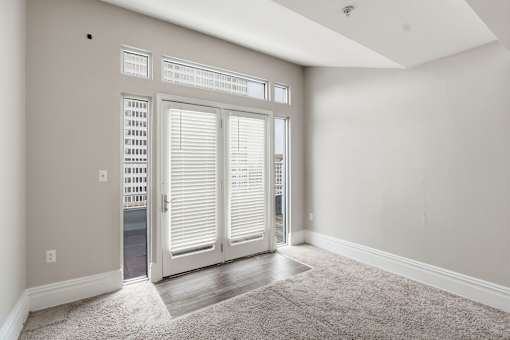 A room with a carpeted floor and a sliding door.