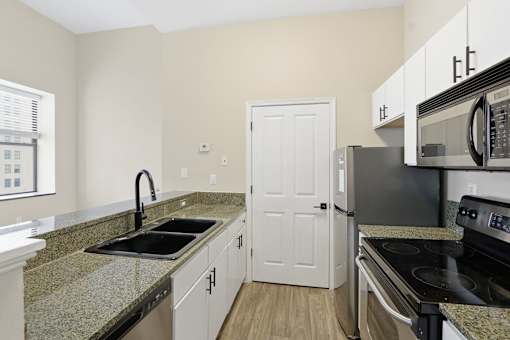 A kitchen with granite countertops and stainless steel appliances.