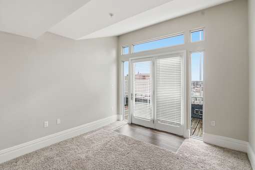 A room with a carpeted floor and a sliding glass door.