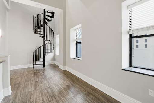 A spiral staircase in a room with light wood flooring.