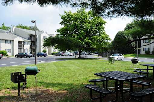 A black picnic table is in the foreground of a grassy area.