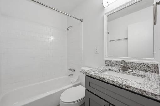 A white bathroom with a tub, toilet, and sink.