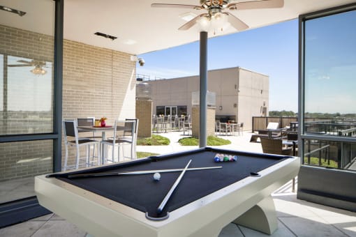 a pool table in the patio of a home with a roof terrace