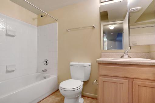 A white toilet sits next to a bathtub in a bathroom.