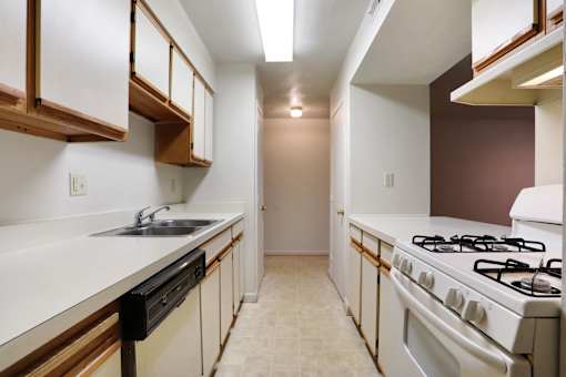 A kitchen with white cabinets and a white stove top oven.